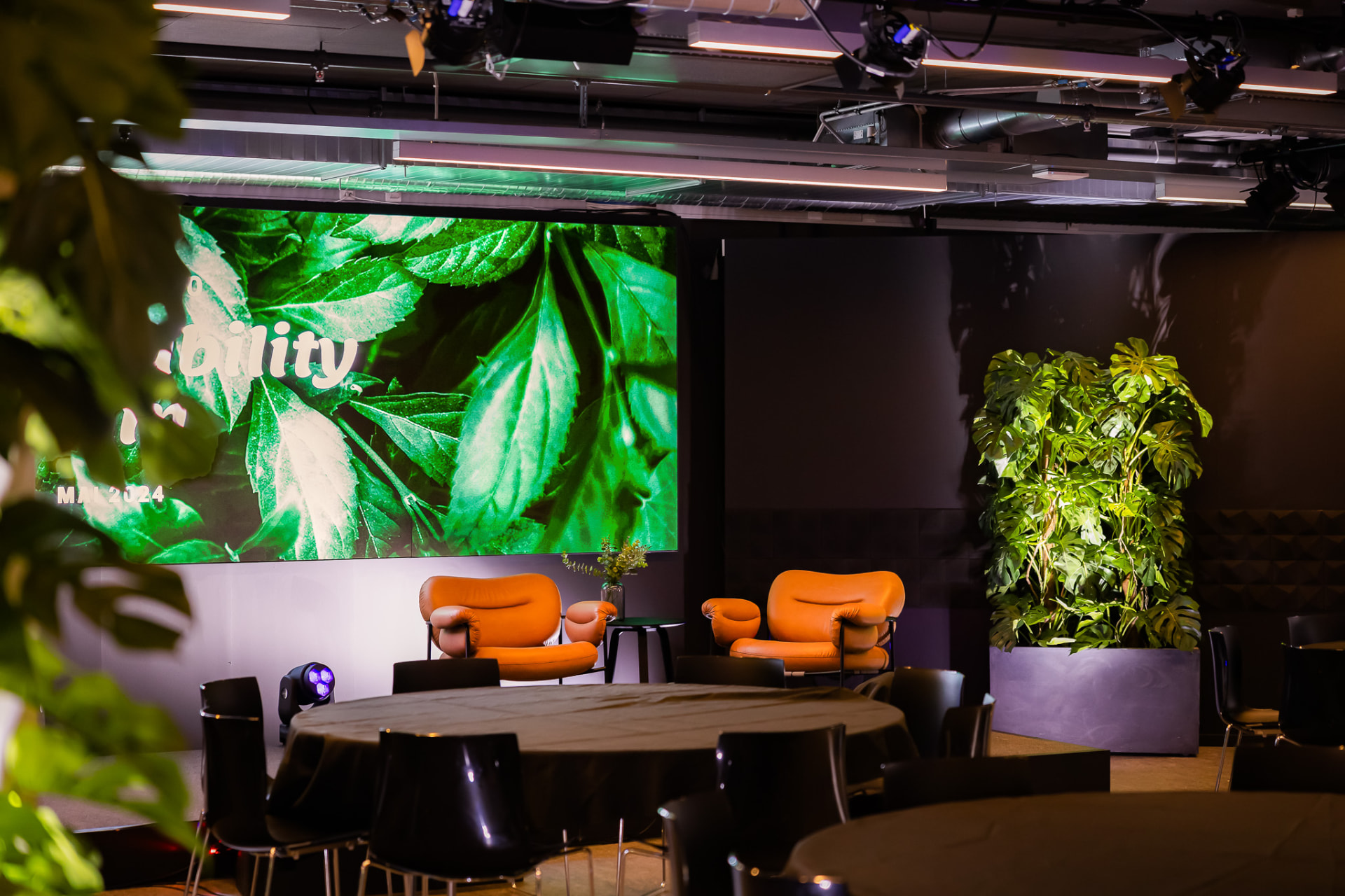 Disruption Hall lounge setup with plants and round tables
